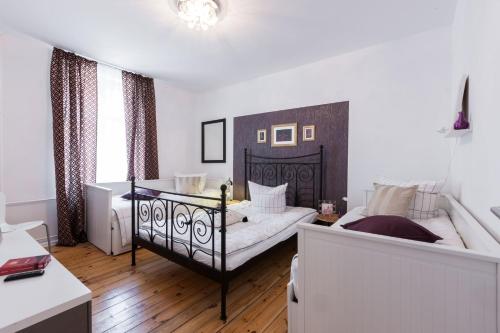 ein Schlafzimmer mit einem Bett und einem Sofa darin in der Unterkunft Elegantes 2-Zimmer-Apartment im Kiez von Prenzlauer Berg in Berlin