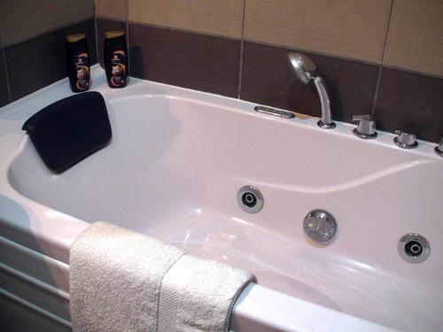 a white bath tub with a towel and a faucet at Apartments Skadarlija in Belgrade