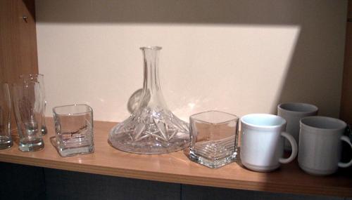 a glass vase and glasses sitting on a shelf at Apartments Skadarlija in Belgrade
