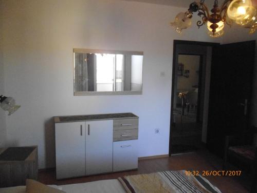 a kitchen with a white cabinet and a mirror at Apartments Lidija in Pag