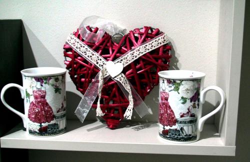 two cups and a red heart on a shelf at Apartments Skadarlija in Belgrade
