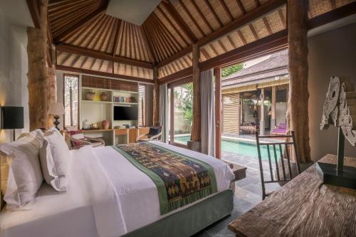 a bedroom with a large bed and a pool at The Purist Villas & Spa Ubud in Ubud