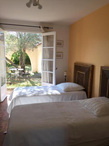 ポルティシオにあるCorse Villa Pieds Dans L Eauのスライド式ガラスドア付きのベッドルーム内のベッド2台