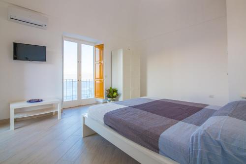 a bedroom with a large bed and a television at Villa Mariagiovanna - Casa Giovanna in Vico Equense
