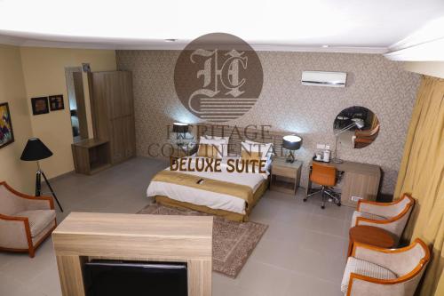 a bedroom with a bed and a desk in a room at Heritage Continental Hotel in Akure