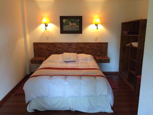 1 cama en un dormitorio con 2 luces en la pared en Hotel Haras Casacampo, en Quintero