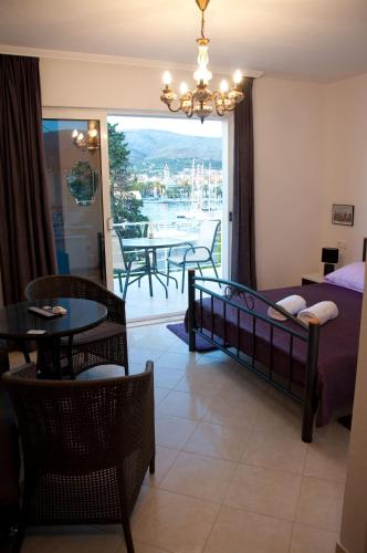 a bedroom with a bed and a balcony with a table at Villa Espero in Trogir