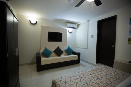 a living room with a couch and a tv at Hotel La Torre San Francisco in San Francisco del Rincón