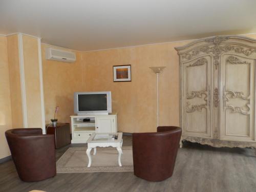Una televisión o centro de entretenimiento en Le Relais des 5 Chateaux