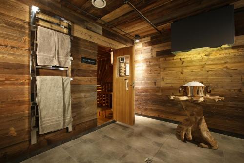 a bathroom with wooden walls and a tv on the wall at Nägler´s Fine Lounge Hotel in Oestrich-Winkel