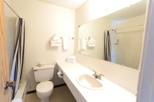 a bathroom with a sink and a toilet and a mirror at Island West Resort in Ucluelet