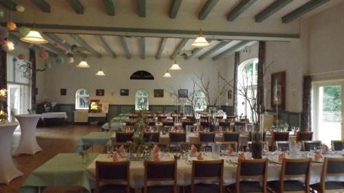 Una gran sala con mesas y sillas. en Drelsdörper Krog, en Drelsdorf