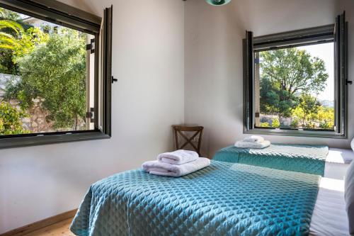 Myrtos Bay Apartments في Anomeriá: سريرين في غرفة بها نافذتين