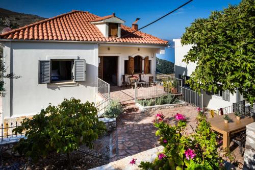 a white house with a red roof at Myrtos Bay Apartments in Anomeriá