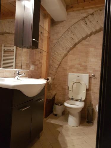a bathroom with a sink and a toilet in a brick wall at Il Purgatorio in Barletta