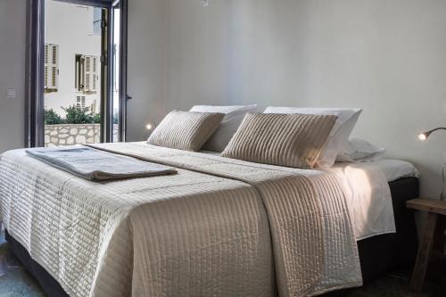 a bedroom with a large bed with white sheets and pillows at Myrtos Bay Apartments in Anomeriá