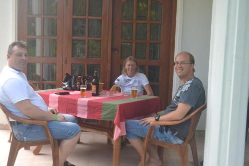 two men and a woman sitting at a table at Kuma Beach side Villa in Wadduwa
