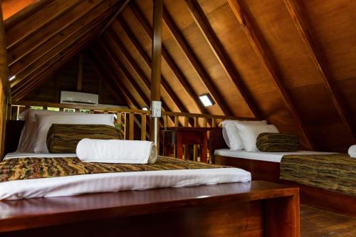 two beds in a room with a roof at Kandy Cabana in Kandy