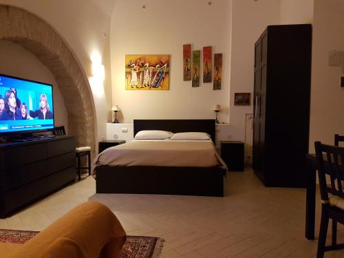 a bedroom with a bed and a flat screen tv at Il Purgatorio in Barletta