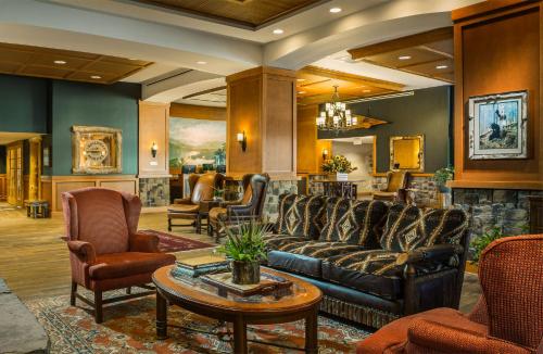 a lobby with a couch and chairs and a table at High Peaks Resort in Lake Placid