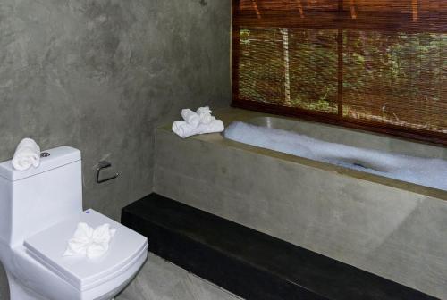 a bathroom with a toilet and a bath tub at Kandy Cabana in Kandy