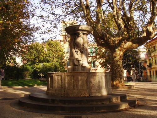 a statue in a park next to a tree at Hermès Suite in Salerno