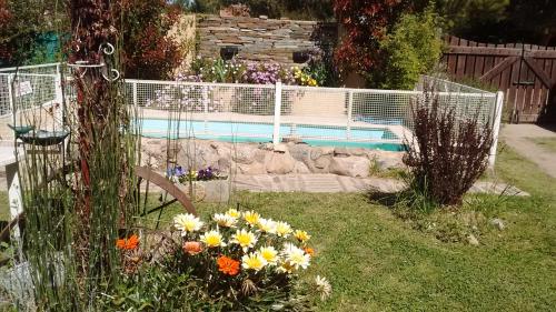 a garden with flowers and a swimming pool at Cabañas Molinos de Vientos in Potrero de los Funes