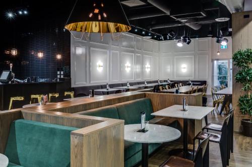 a restaurant with tables and chairs and a bar at Heritage Inn Hotel & Convention Centre - Brooks in Brooks