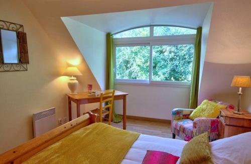 um quarto com uma cama, uma janela e uma cadeira em gites de rêve en Finistère em Quéménéven