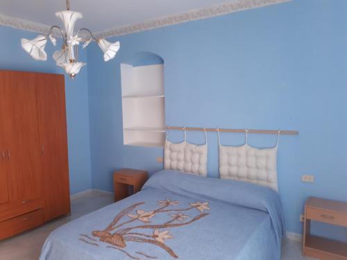 a blue bedroom with a bed with a tree on it at Casa Stella Marina in Carbonia