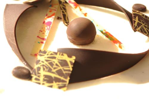 a chocolate candy on a plate with a spoon at Albergo Ester in Piandimeleto