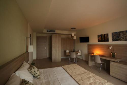 a living room with a bed and a desk in a room at Turin Airport Hotel & Residence in San Francesco al Campo