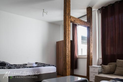 フュルトにあるSmart and Happy Living Fürthのベッドと窓が備わる小さな客室です。