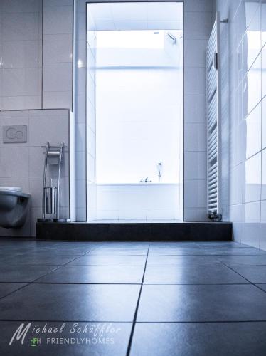 a bathroom with a toilet and a large window at Smart and Happy Living Fürth in Fürth