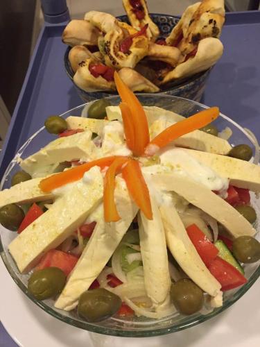 a bowl of food with vegetables and hot dogs on a table at King Hotel in Peje