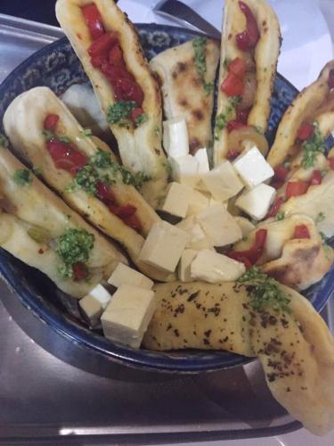 a blue plate of food with pizza and cheese at King Hotel in Peje