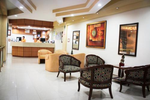 a waiting room with chairs and a table and a counter at Intiotel Chiclayo in Chiclayo