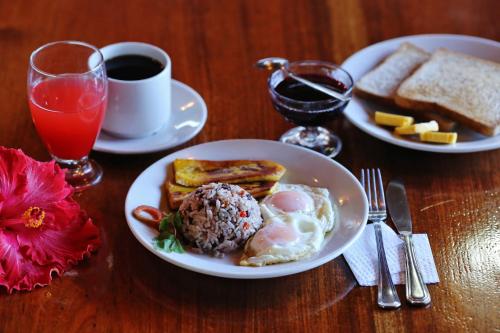 un tavolo con due piatti per la colazione e una tazza di caffè di Hotel El Atardecer a Monteverde Costa Rica