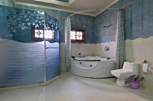 a bathroom with a bath tub and a toilet at Hotel Blue Sky Executive in Karachi