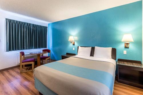 a hotel room with a large bed and a table at Motel 6-Astoria, OR in Astoria, Oregon