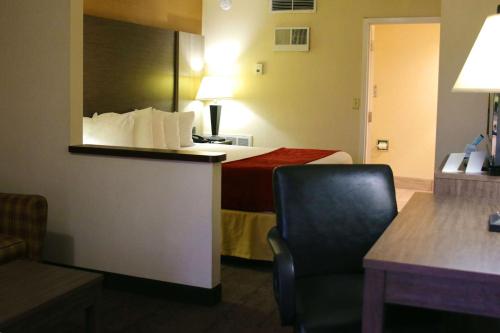 a hotel room with a bed and a chair at Best Western Galleria Inn & Suites in Cheektowaga