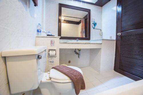 uma casa de banho com um WC, um lavatório e um espelho. em Nova Samui Resort em Chaweng