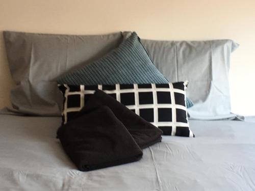 a bed with black and white pillows on it at Caramel in Turnhout