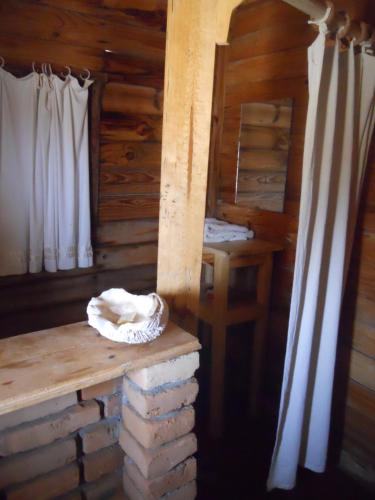 a room in a log cabin with a bench and curtains at Longo Vezo in Anakao