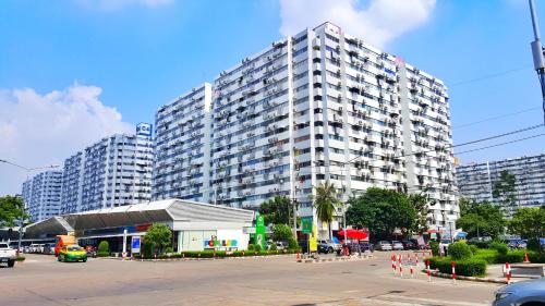 a large building with a parking lot in front of it at Popular Condo by Jintana in Pak Kret