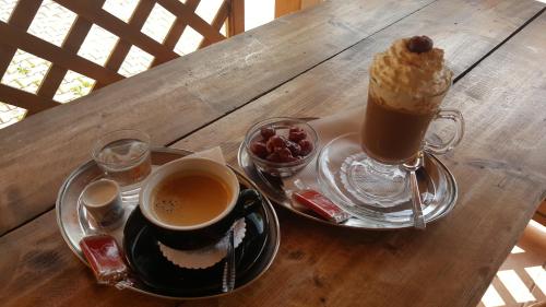 a table with a cup of coffee and a bowl of fruit at Penzion Ustie in Trstená