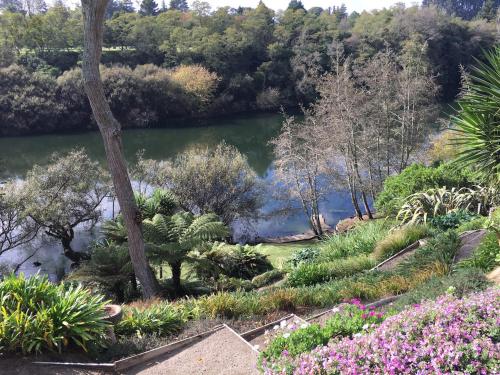 a view of a garden with flowers and a lake at On The River in Hamilton