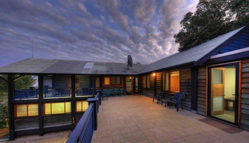 a house with a large deck with a patio at Fraser Island Retreat in Fraser Island