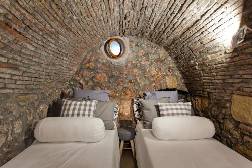 - 2 lits dans une chambre avec un mur en briques dans l'établissement Nido al Mare - by Vacation Service, à Cefalù
