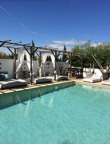 une grande piscine avec des chaises et une pergola dans l'établissement Terre de Boheme, à Vestric-et-Candiac